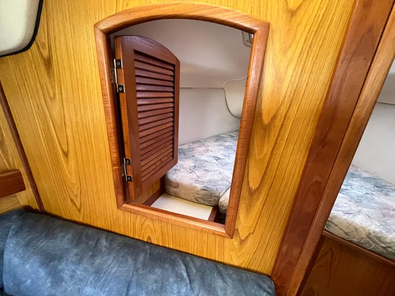 Slide: The Image of Interior of 2000 Hunter 340 sailboat with wooden cabin door and cozy bedding. - 25