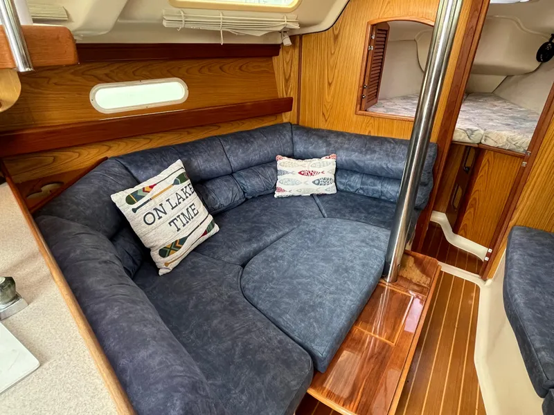 Slide: The Image of Cozy interior of 2000 Hunter 340 sailboat with blue seating and decorative pillows. - 26