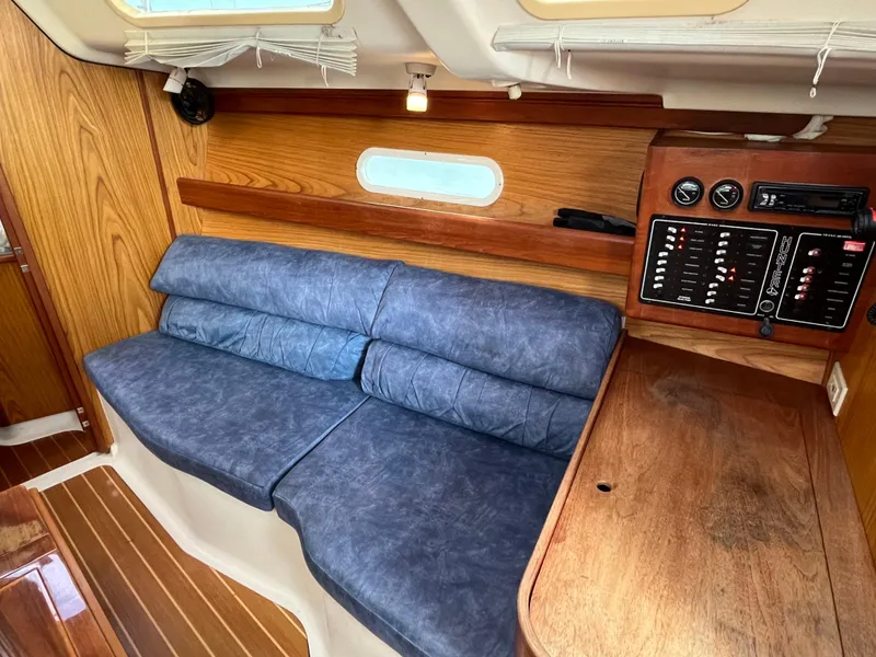 Slide: The Image of Interior of a 2000 Hunter 340 sailboat with blue seating and wooden paneling. - 29