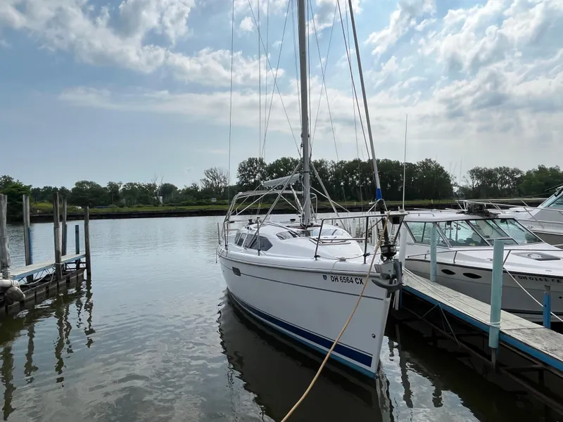 Slide: The Image of Sailboat Hunter 340, 2000 model, docked at a marina under a partly cloudy sky. - 3