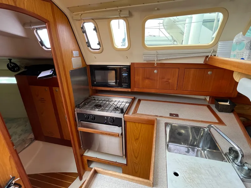 Slide: The Image of Compact kitchen in a 2000 Hunter 340 sailboat with stove, microwave, and sink. - 36