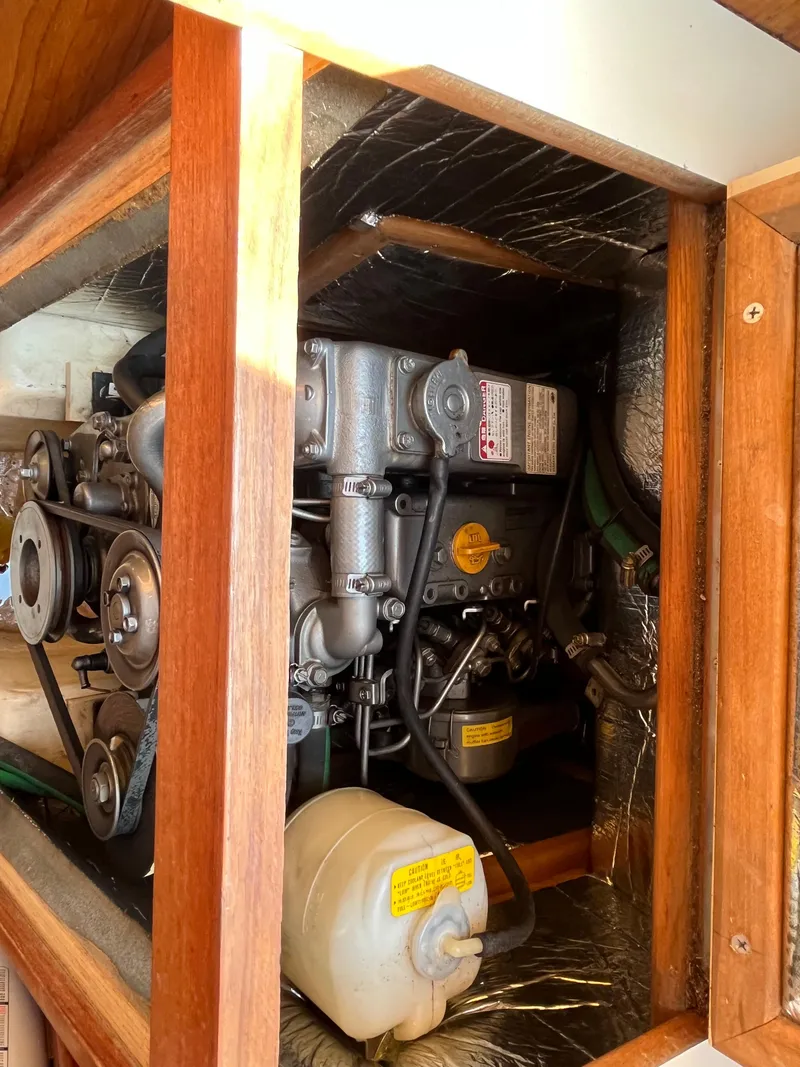 Slide: The Image of Engine compartment of a 2000 Hunter 340 sailboat, showcasing mechanical components and wooden framing. - 40