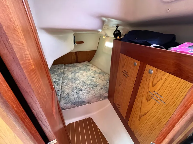 Slide: The Image of Cozy cabin interior of 2000 Hunter 340 sailboat with wooden cabinetry and bed. - 42