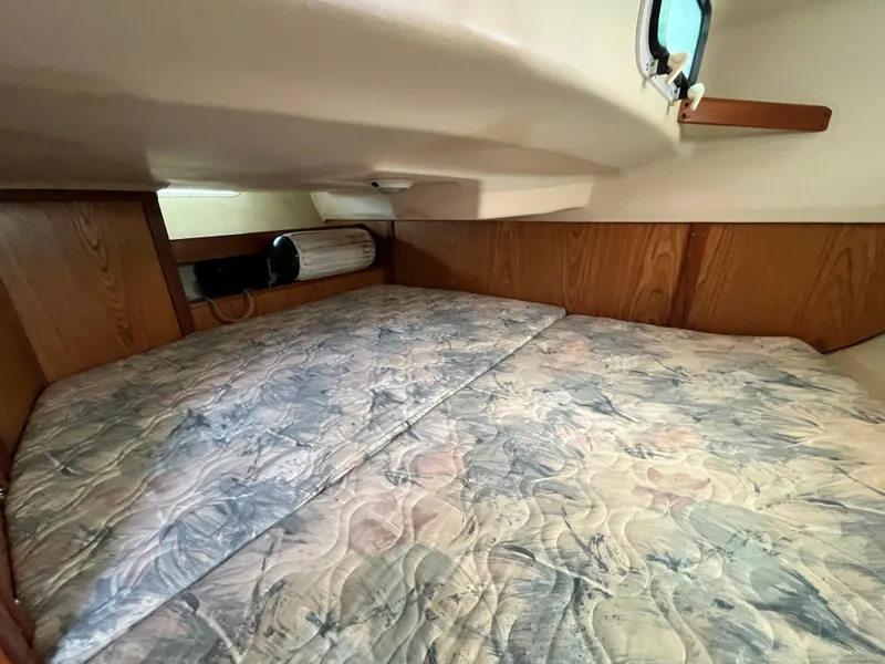 Slide: The Image of Cozy cabin interior of 2000 Hunter 340 sailboat with patterned mattress and wooden accents. - 44