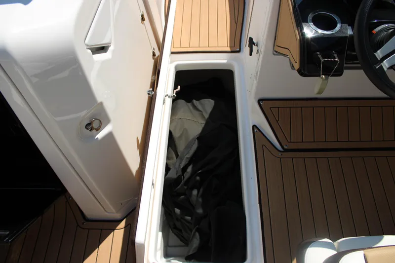 Slide: The Image of 2022 Yamaha Boats 252S interior storage compartment with teak-style flooring. - 11