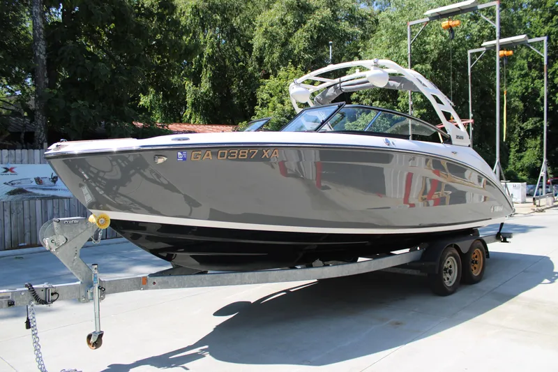 Slide: The Image of 2022 Yamaha Boats 252S on trailer, parked outdoors, surrounded by trees. - 3