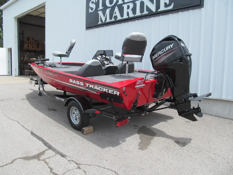 Slide: The Image of 2014 Tracker Pro Team 175 TXW bass boat with Mercury engine, parked outside a marine store. - 3