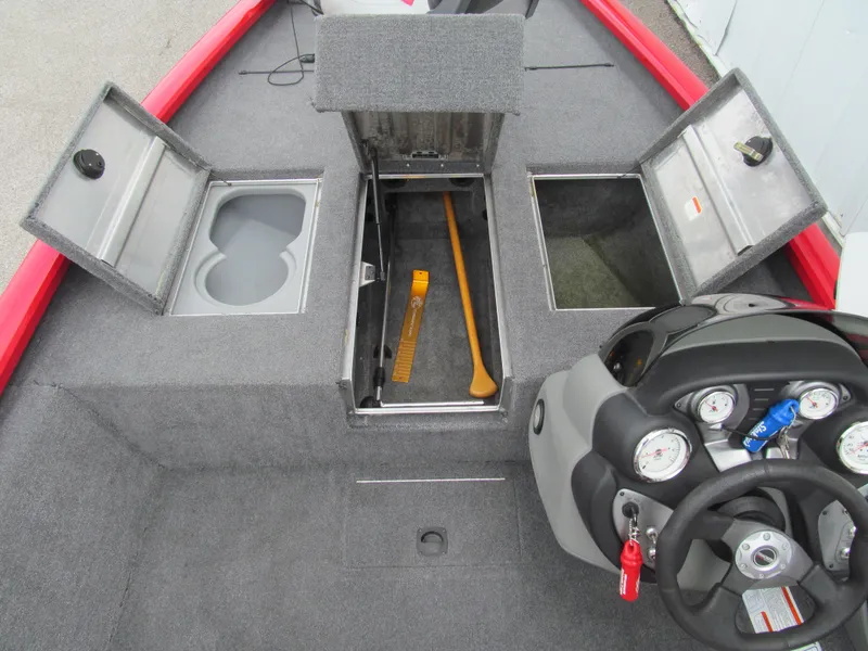 Slide: The Image of 2014 Tracker Pro Team 175 TXW boat interior with open storage compartments and steering console. - 8