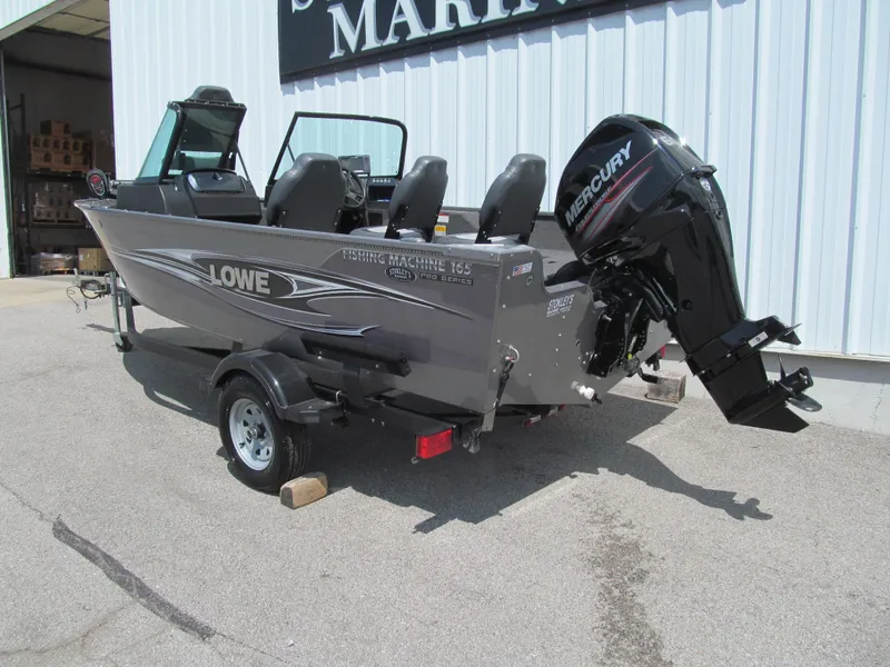 Slide: The Image of 2017 Lowe FM 165 Pro WT fishing boat with Mercury outboard motor, parked outside a marina. - 3