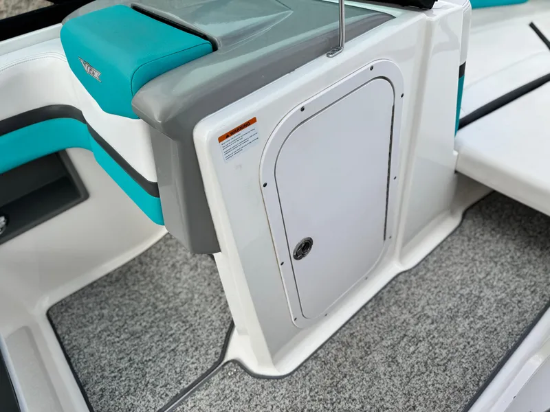 Slide: The Image of 2015 Chaparral Vortex 203 VRX boat interior with teal seating and storage compartment. - 27