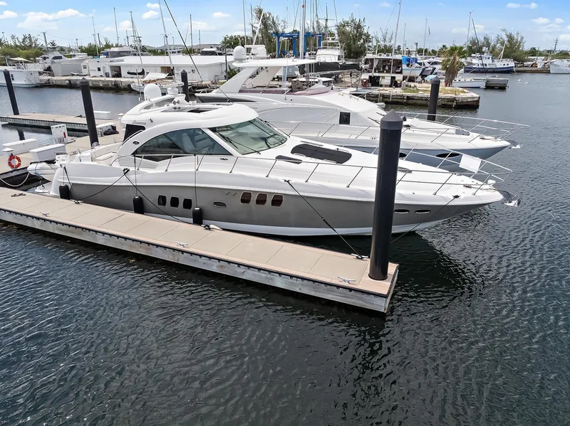 Slide: The Image of 2006 Sea Ray 60 Sundancer yacht docked at marina, calm waters, clear sky. - 27