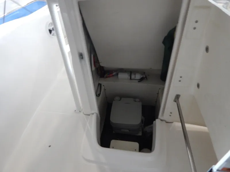 Slide: The Image of 2019 Robalo R202 Explorer boat interior with storage compartment and portable toilet. - 12