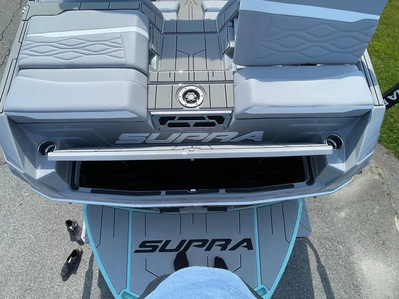 Slide: The Image of 2025 Supra SL boat interior with gray seating and logo, viewed from above. - 13