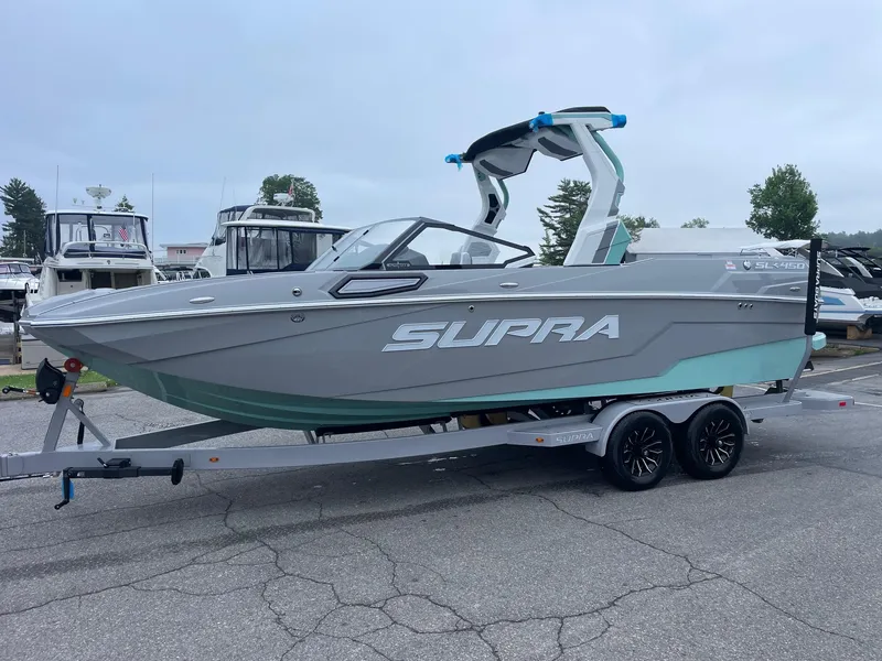 Slide: The Image of 2025 Supra SL boat on trailer, sleek design, parked in marina. - 3
