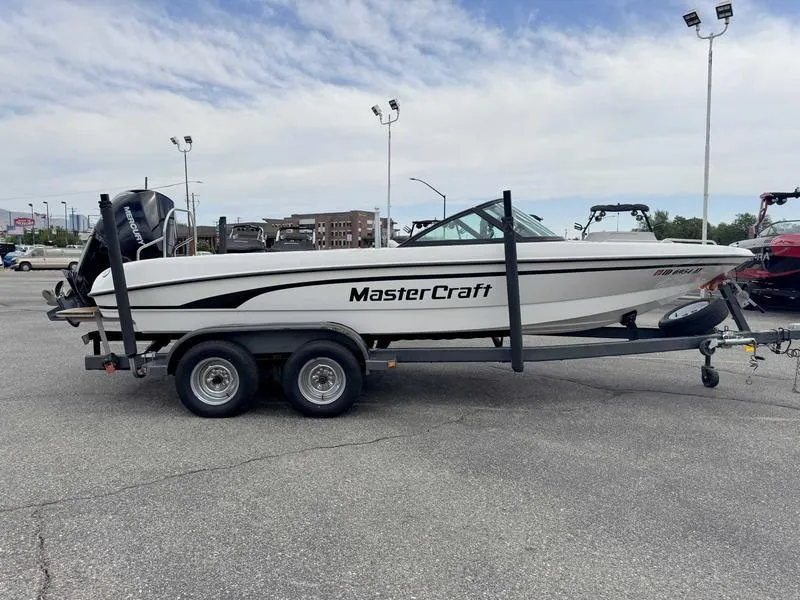 Slide: The Image of 1999 MasterCraft Powerstar 200 boat on trailer in parking lot. - 1
