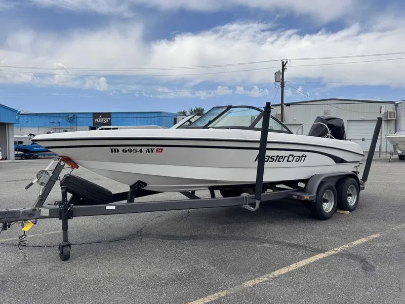 Slide: The Image of 1999 MasterCraft Powerstar 200 boat on trailer in parking lot, clear sky background. - 4