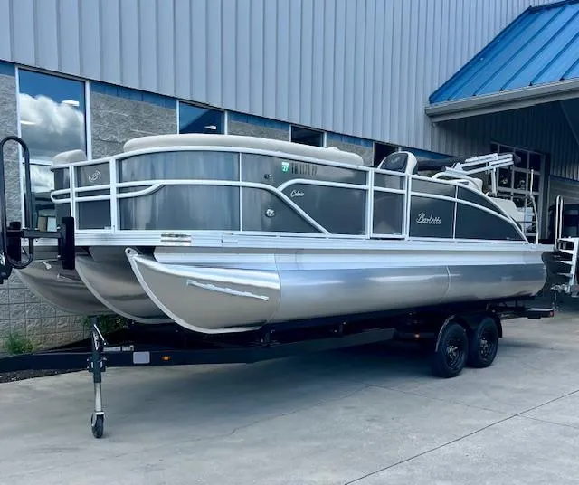 Slide: The Image of 2023 Barletta Cabrio 22UC pontoon boat on trailer outside a building. - 1
