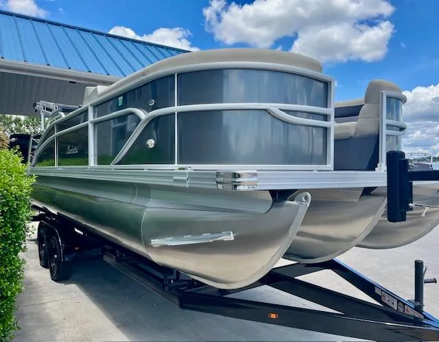 Slide: The Image of 2023 Barletta Cabrio 22UC pontoon boat on trailer under blue sky. - 2