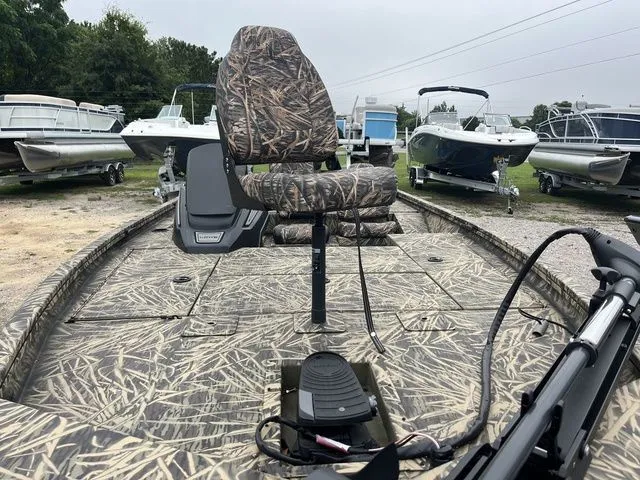Slide: The Image of 2024 Lowe Stinger 175C boat with camouflage seating, parked among other boats. - 10