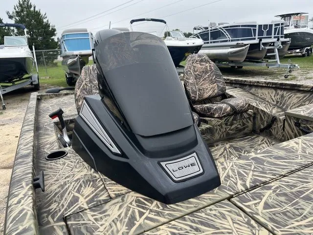 Slide: The Image of 2024 Lowe Stinger 175C boat with camouflage seats and console, displayed outdoors. - 11