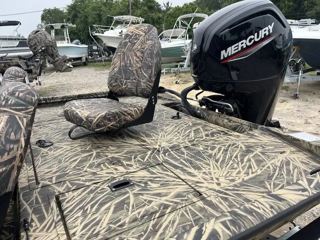 Slide: The Image of 2024 Lowe Stinger 175C boat with camo seats and Mercury outboard motor. - 13
