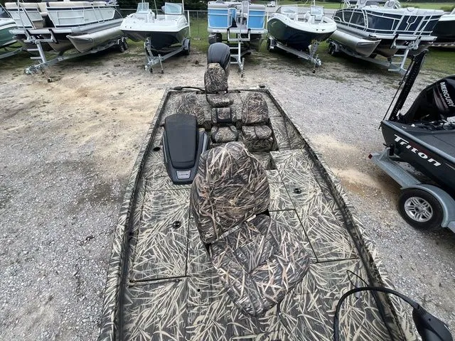 Slide: The Image of 2024 Lowe Stinger 175C boat with camouflage seats, parked among other boats. - 16