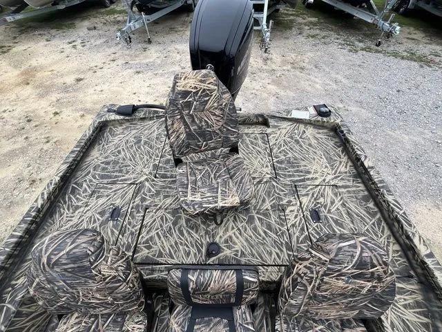 Slide: The Image of 2024 Lowe Stinger 175C boat with camouflage seating and deck, parked on gravel. - 19