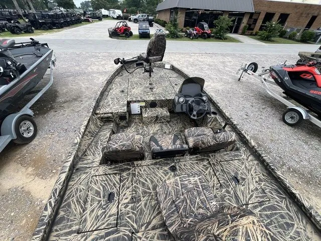 Slide: The Image of 2024 Lowe Stinger 175C boat with camouflage design, parked outdoors on gravel. - 21