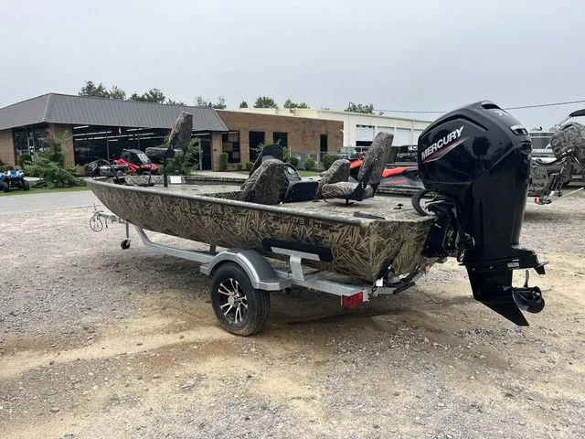 Slide: The Image of 2024 Lowe Stinger 175C boat with Mercury engine on a trailer, parked outdoors. - 4