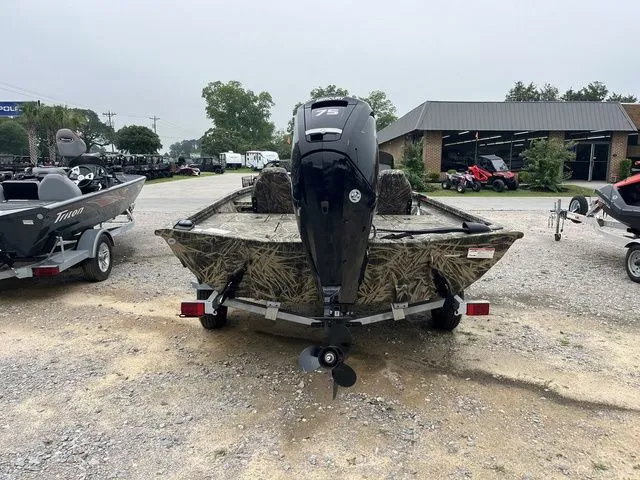 Slide: The Image of 2024 Lowe Stinger 175C boat with camouflage design, parked outdoors on gravel. - 5