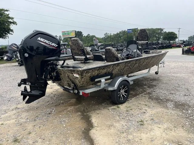 Slide: The Image of 2024 Lowe Stinger 175C boat with Mercury engine on a trailer, parked outdoors. - 6