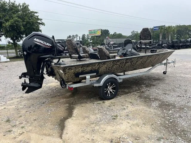 Slide: The Image of 2024 Lowe Stinger 175C boat with Mercury engine on a trailer, parked outdoors. - 7
