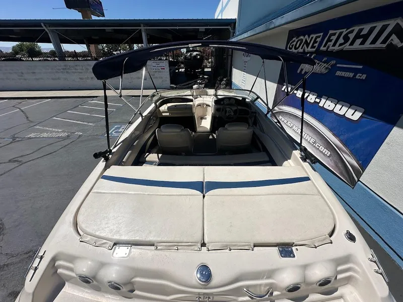 Slide: The Image of 2001 Larson SEi 190 boat with canopy, parked near a blue building. - 12