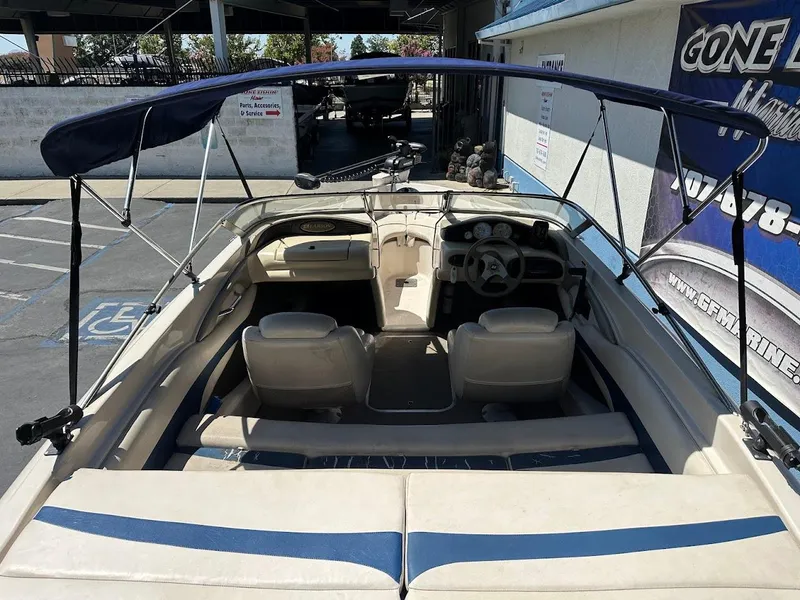 Slide: The Image of 2001 Larson SEi 190 boat interior with seating and steering wheel, under a canopy. - 13