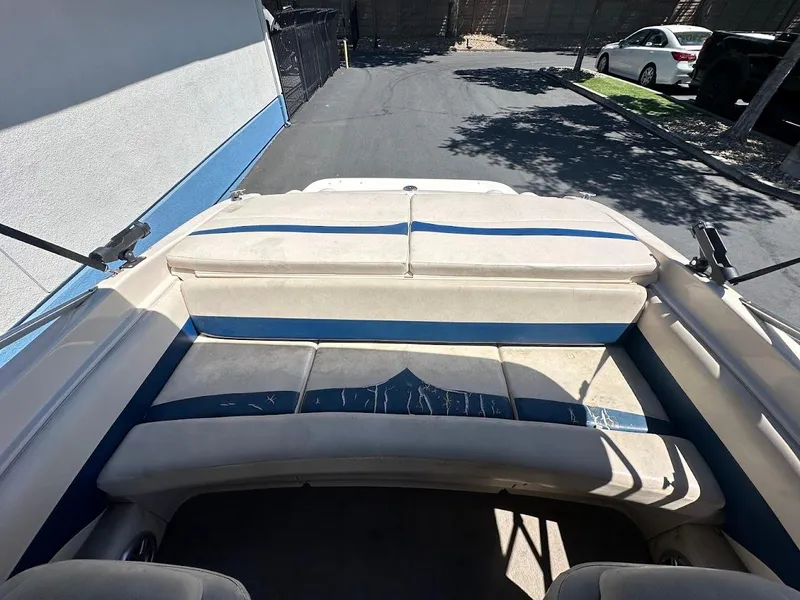 Slide: The Image of 2001 Larson SEi 190 boat interior with blue and white seating, parked outdoors. - 15