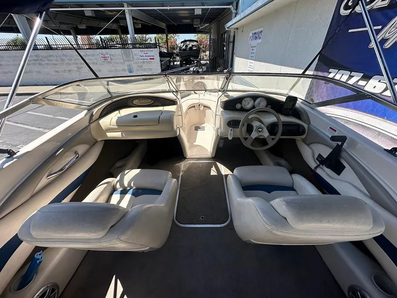 Slide: The Image of Interior of a 2001 Larson SEi 190 boat, featuring beige seating and steering console. - 16