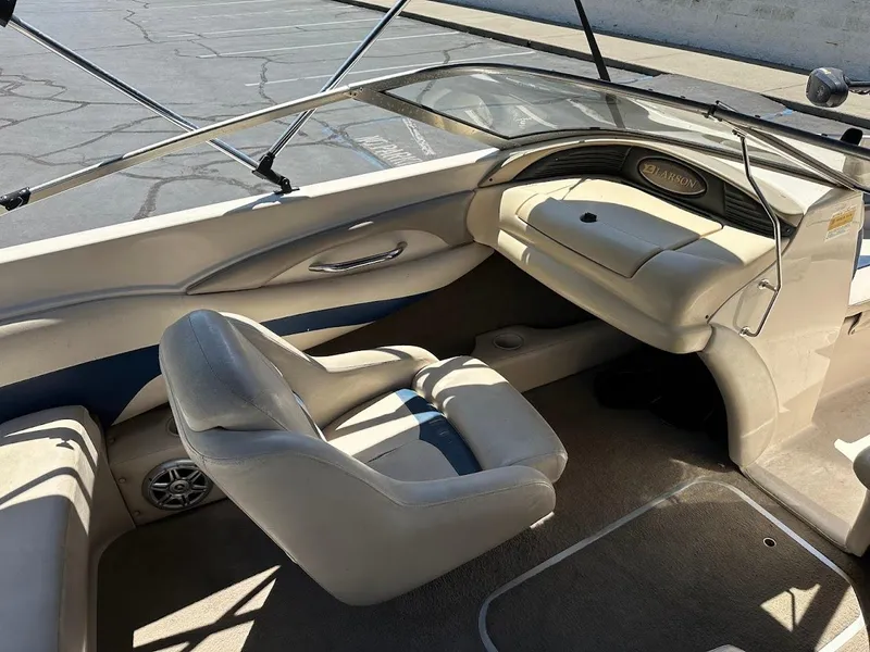 Slide: The Image of Interior of a 2001 Larson SEi 190 boat, featuring beige seating and dashboard. - 17