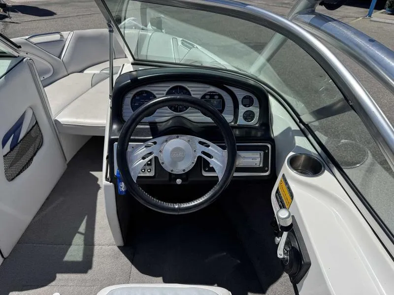 Slide: The Image of Interior of a 2006 Custom B52 23 boat, featuring steering wheel and dashboard controls. - 10