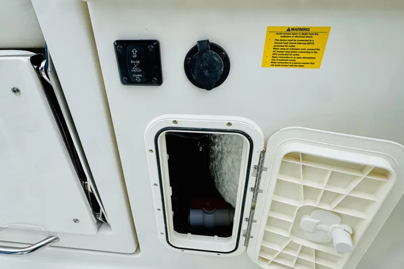 Slide: The Image of 2026 Sailfish 276 DC boat compartment with hatch, warning label, and control switch. - 13