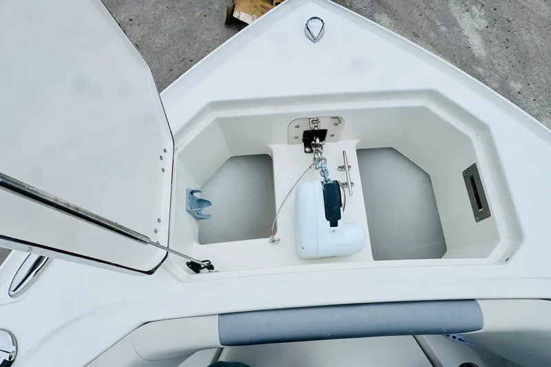 Slide: The Image of Open anchor compartment on 2026 Sailfish 276 DC boat, showcasing storage and anchor mechanism. - 16