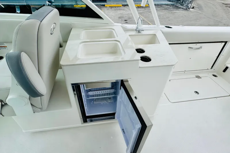Slide: The Image of 2026 Sailfish 276 DC boat interior with sink, fridge, and seating. - 19