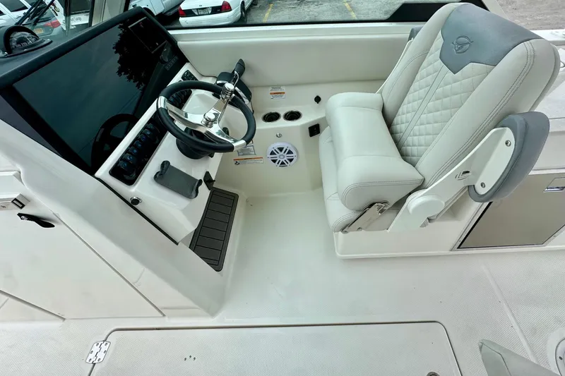 Slide: The Image of 2026 Sailfish 276 DC boat cockpit with steering wheel and cushioned seat. - 23