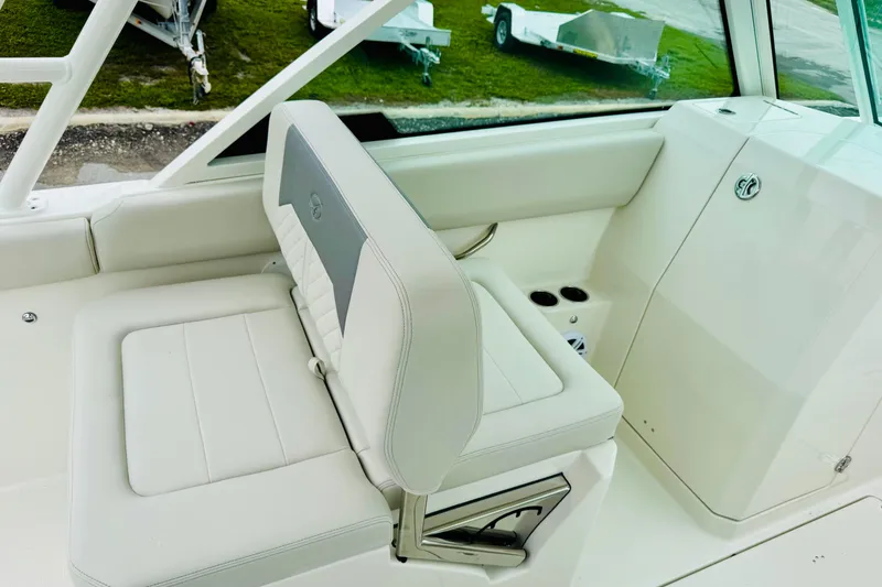 Slide: The Image of 2026 Sailfish 276 DC boat interior with white seating and storage compartment. - 28