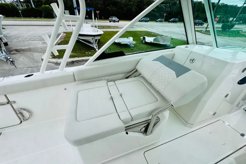 Slide: The Image of 2026 Sailfish 276 DC boat interior with white cushioned seating and stainless steel accents. - 29