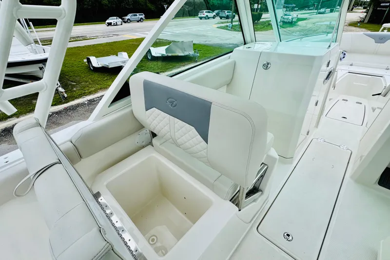 Slide: The Image of 2026 Sailfish 276 DC boat interior with white seating and storage compartment. - 33