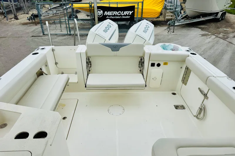 Slide: The Image of 2026 Sailfish 276 DC boat interior with seating and Mercury engines in a dealership setting. - 36