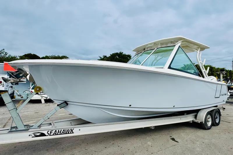 Slide: The Image of 2026 Sailfish 276 DC boat on Seahawk trailer, parked outdoors under cloudy sky. - 5