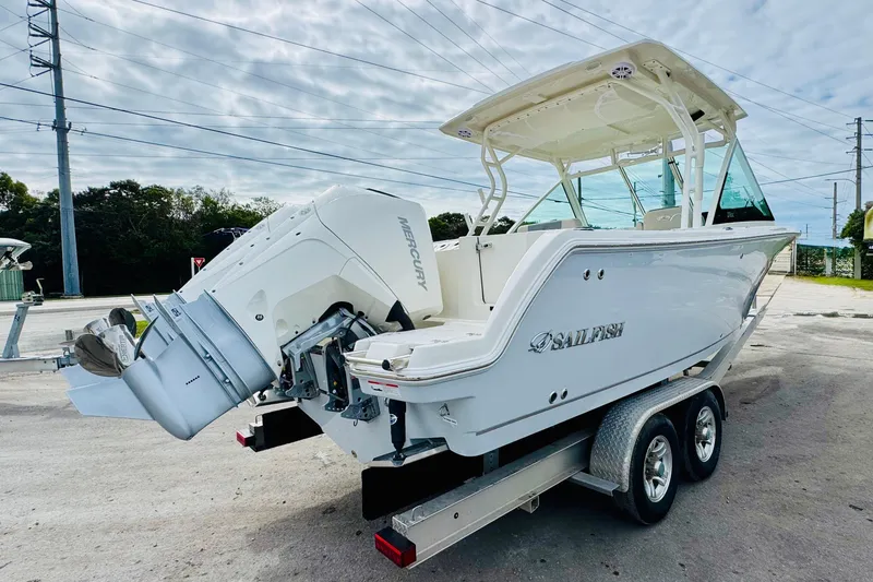 Slide: The Image of 2026 Sailfish 276 DC boat on trailer with Mercury outboard engine, parked outdoors. - 6