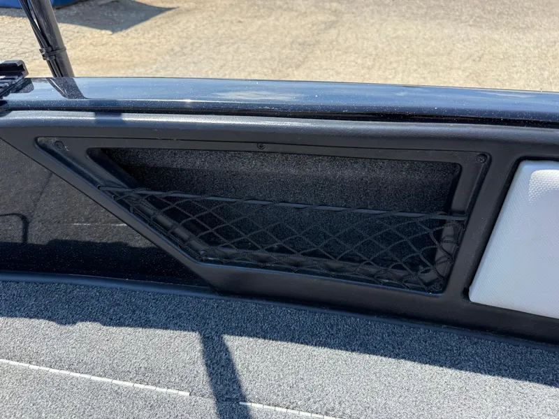 Slide: The Image of Storage compartment on a 2022 Ranger 1880MS boat with netting and carpeted interior. - 15