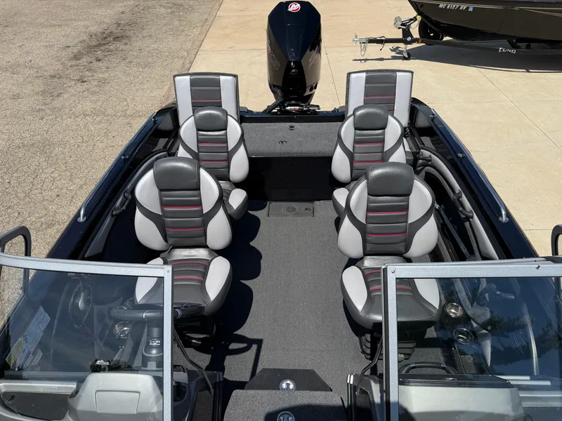 Slide: The Image of 2022 Ranger 1880MS boat interior with six seats and a motor, parked on concrete. - 19